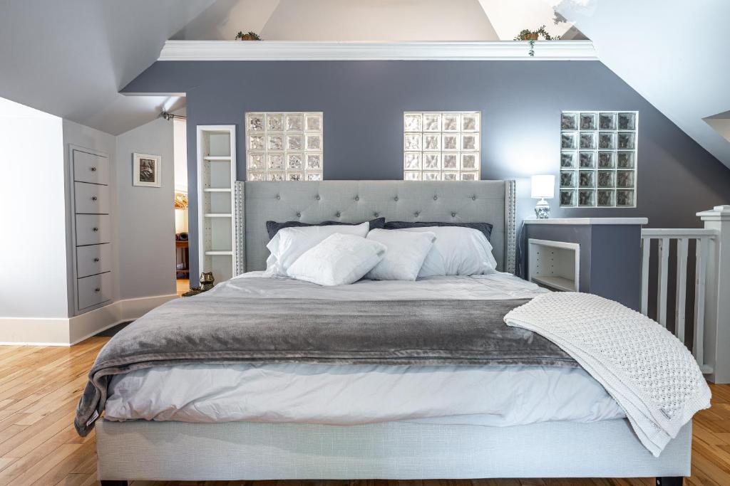 une chambre avec un grand lit aux murs bleus dans l'établissement Glyn Rhosyn Balcony Riverview, à Stratford