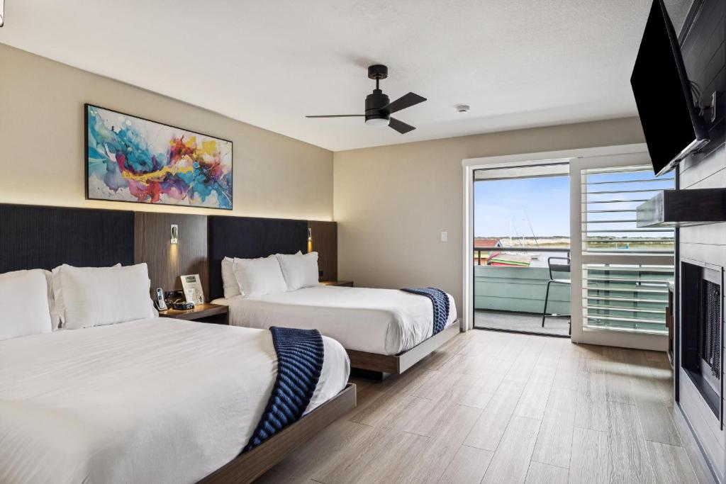a hotel room with two beds and a television at 456 Embarcadero Inn & Suites in Morro Bay
