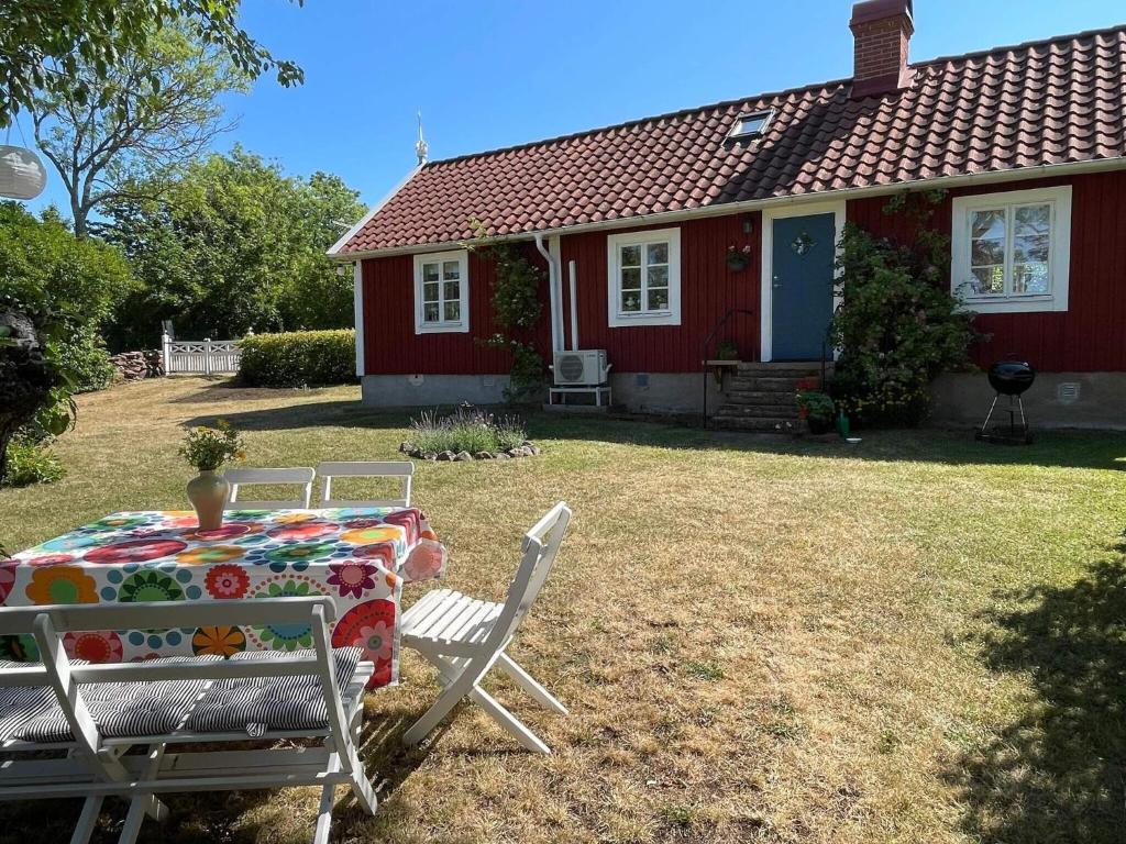 a table and chairs in front of a red house at 4 star holiday home in Borgholm in Borgholm