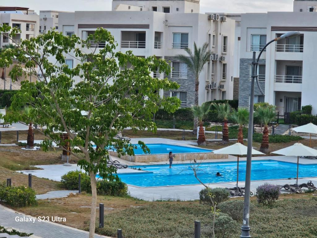 ein Bild von einem Swimmingpool in einem Ferienresort in der Unterkunft Amwaj sidi abed el rahman in Banī Ghālib