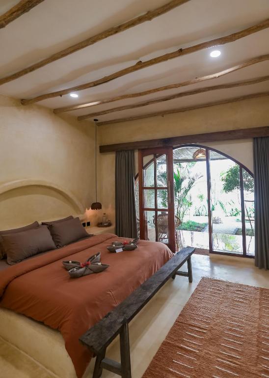 吉利特拉旺安Amani的一间卧室，配有一张大床和一扇大窗户。