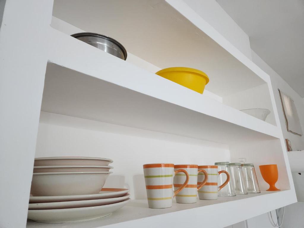 a white cabinet with plates and bowls and bowls at Delfines in Las Grutas