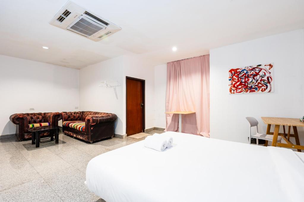 a hotel room with a bed and a couch at X Mitr INN Sukhumvit 2 - BTS Nana มิตร อินน์ สุขุมวิทซอย 2 บีทีเอส นานา in Bangkok