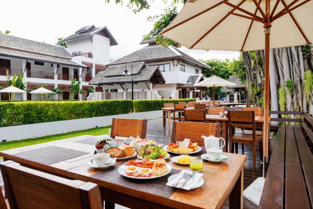 An outdoor breakfast table set beside the resort's landscaped courtyard.