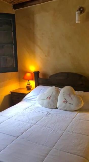 a bedroom with a large white bed with two pillows at Solue in Duitama