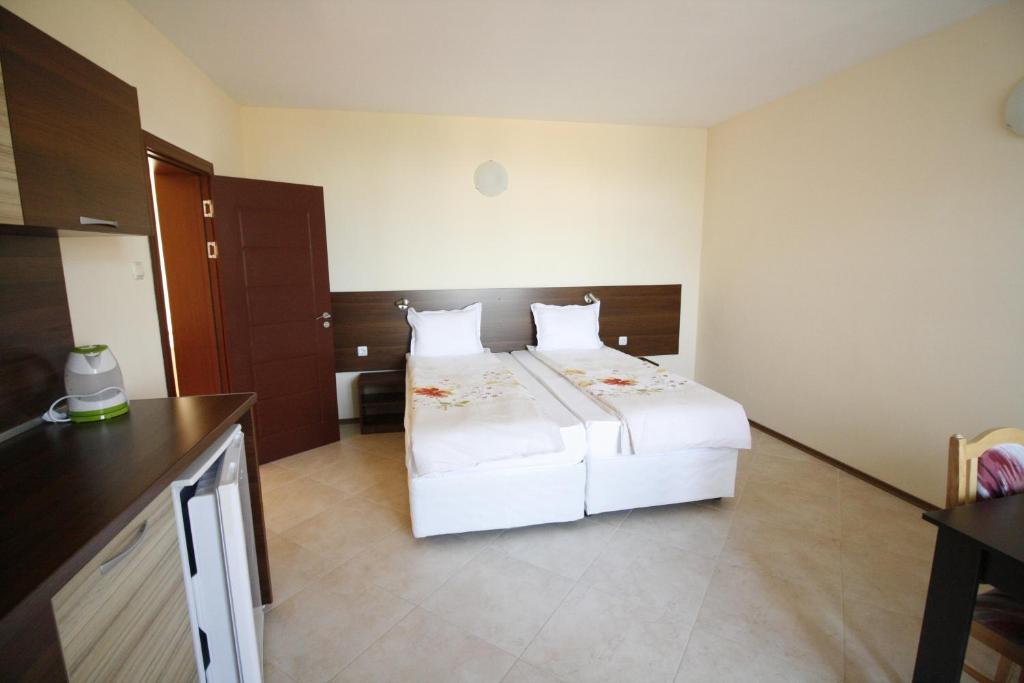 a bedroom with a large white bed in a room at Hotel Marant in Sozopol