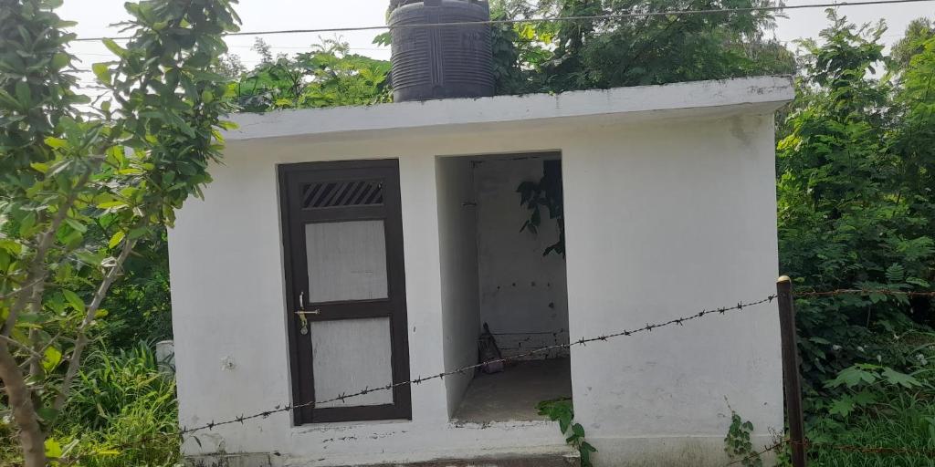 a small white building with a door and a chimney at Rohit PRATAP SINGH in Lucknow