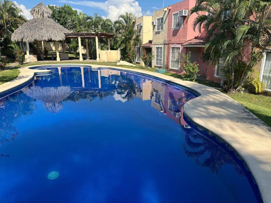 Una gran piscina azul frente a una casa en Casa Flamingo 3 Recamaras, 3 Baños completos, en Ixtapa
