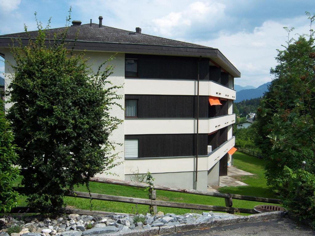 un edificio blanco con ventanas negras en el lateral. en Edelweiss Residenza Quadra, en Flims