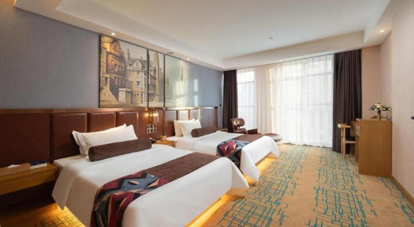 a hotel room with two beds and a large window at James Joyce Coffetel· Changde Liuyehu in Changde