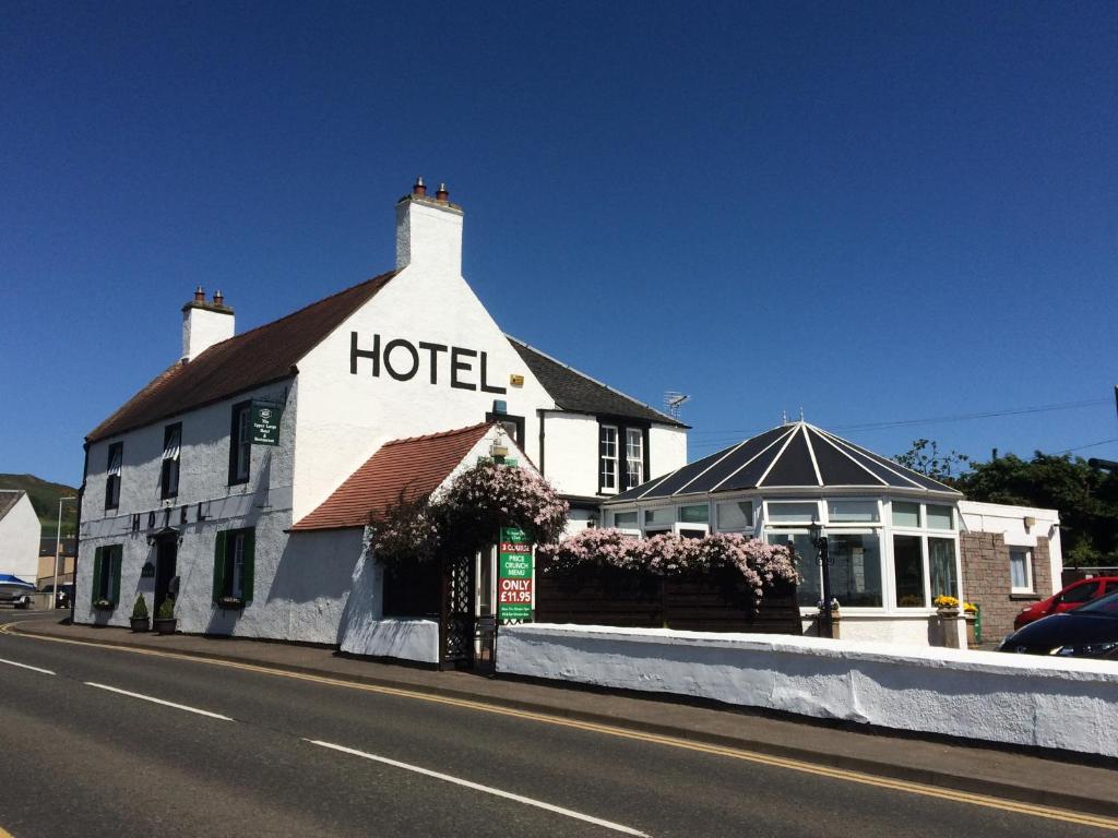 
a store front with a sign on the side of the street at The Upper Largo Hotel & Restaurant in Lundin Links
