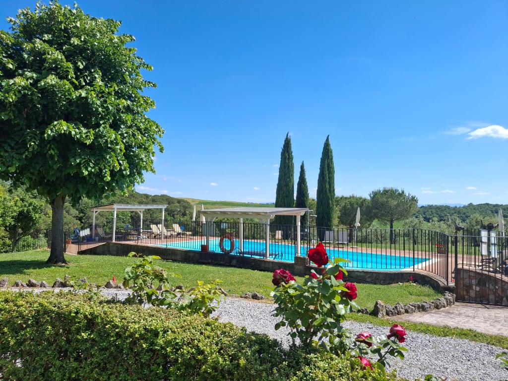 a swimming pool in a park with a garden at Casa Vacanze Il Fornacino in Asciano