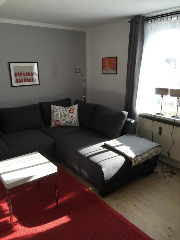 sala de estar con sofá negro y ventana en SEELIG`S en Weinsheim