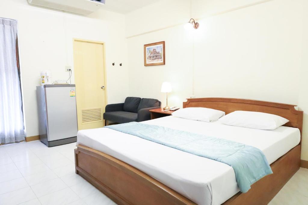 un dormitorio con una cama y una silla en Phawana Sweet Hotel, en Bangkok