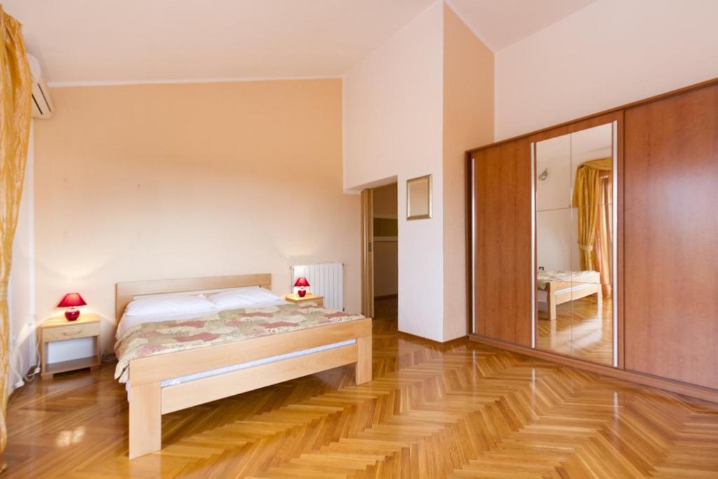 a bedroom with a bed and a large mirror at House Ivica in Banjole
