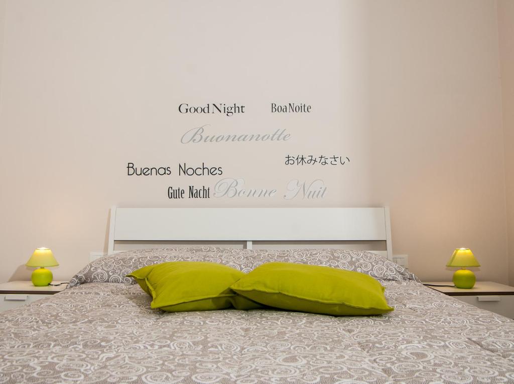 1 dormitorio con 1 cama con almohadas verdes en B&B Notti Sikane, en Porto Empedocle
