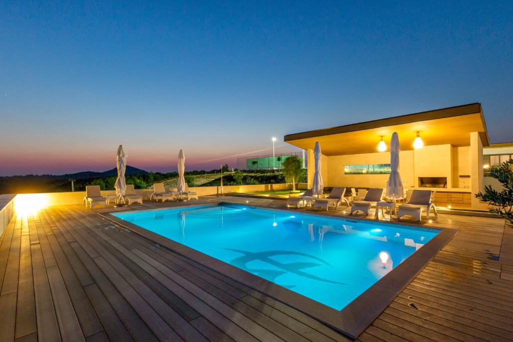 ein Swimmingpool auf einem Holzdeck bei Nacht in der Unterkunft Villa Amalia in Zastražišće