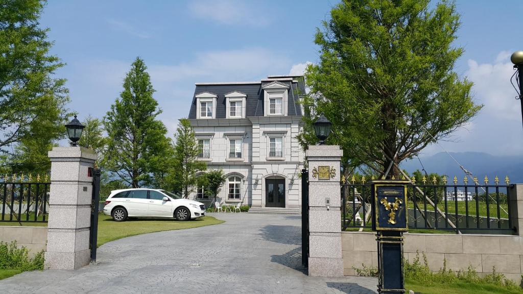 un coche blanco estacionado frente a una casa en Haut Rhin Villa, en Zhuangwei