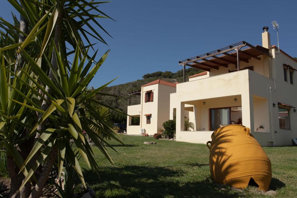 a large yellow barrel sitting in the yard of a house at Villa Spiti Louloudis in Spílion