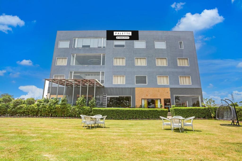 a building with tables and chairs in front of it at Palette Hotel and Resort Bareilly Formerly Bellazio Suites in Bareilly