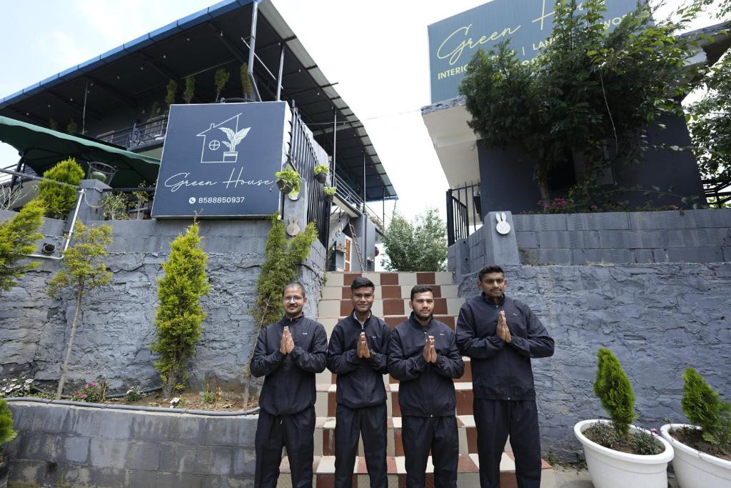a group of men praying in front of a building at Green House Luxury Home Stay in Mukteswar