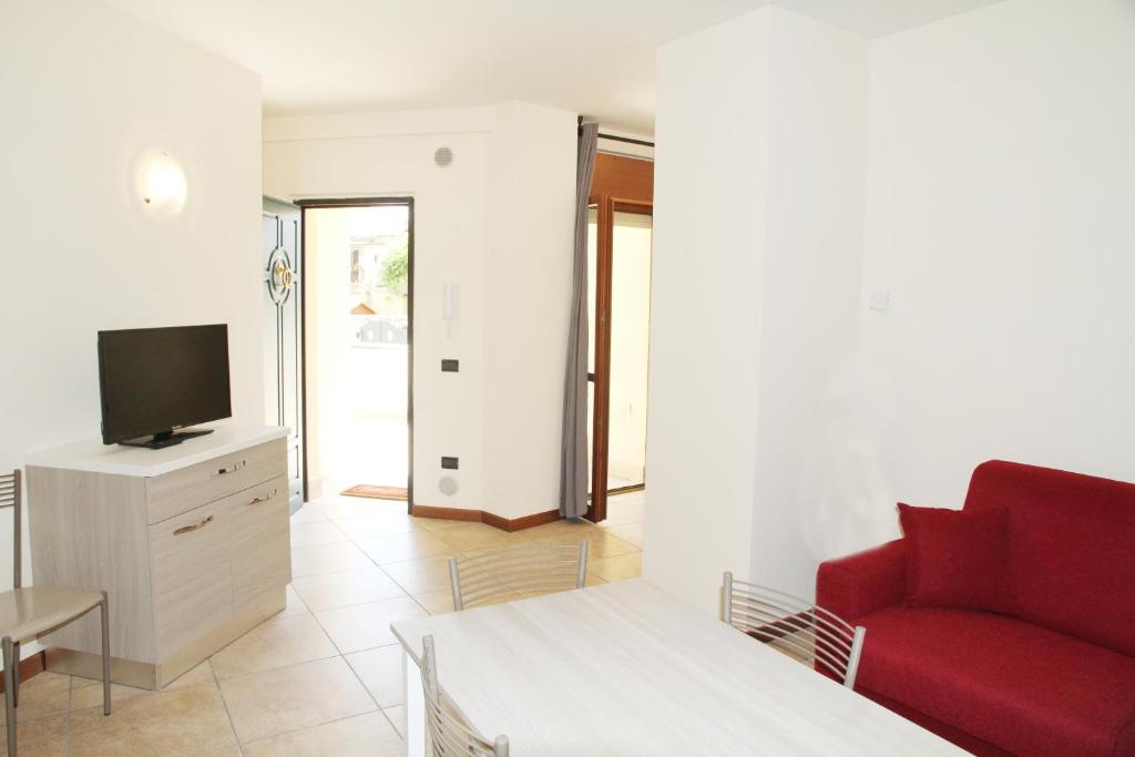 ein Wohnzimmer mit einem roten Sofa und einem TV in der Unterkunft Appartamenti Il Cerqueto 2 in Terni