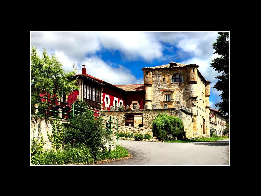 un gran edificio de piedra con techo rojo en Palacio de los Alvarado en El Ribero