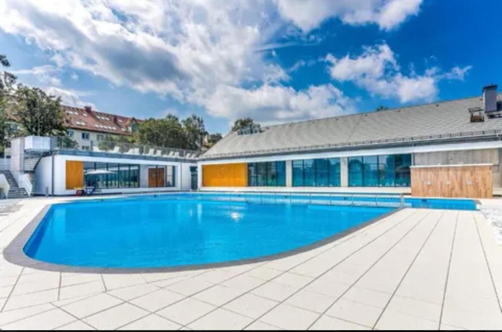 a swimming pool in front of a building at SEA & SMILE APARTMENT - BASEN, SAUNA, PARKING, WIFI, SPA Kołobrzeg Podczele in Kołobrzeg