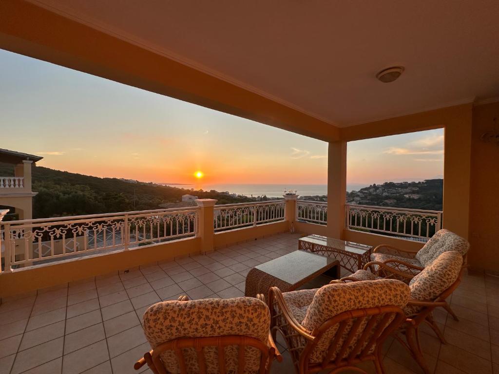 balcone con sedie e tramonto sullo sfondo di Sunsets and large pool in comfy Villa Avra Arillas a Arillas