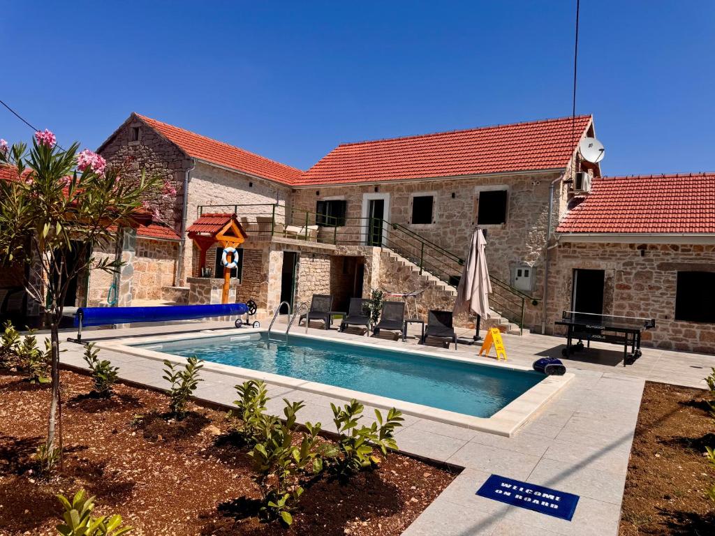 a swimming pool in front of a house at Villa Zvonimir in Suknovci