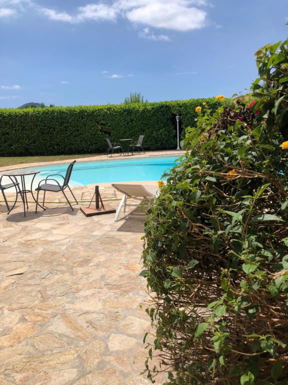 a swimming pool with two chairs and a table at Les Cigales in La Crau