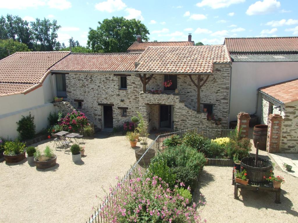 a stone house with a garden with potted plants at Fleur de Vigne in Monnières
