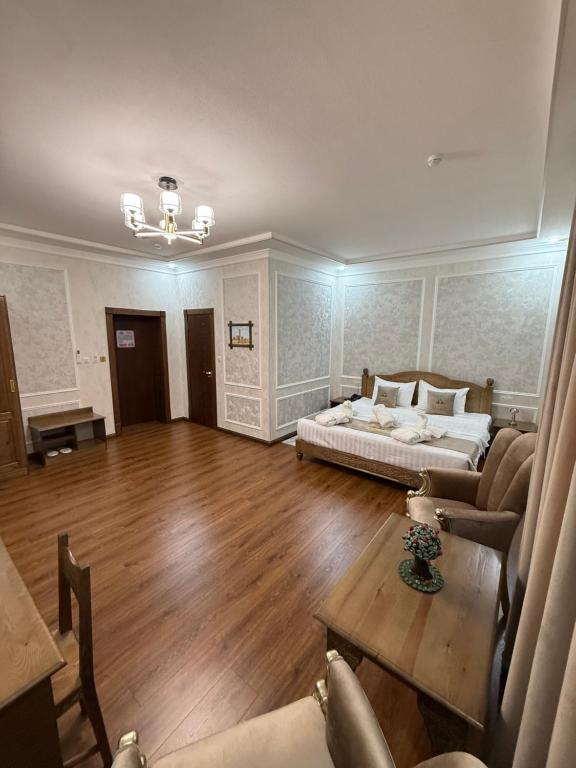 Una gran sala de estar con una cama y una mesa. en Shergiron Plaza, en Bukhara