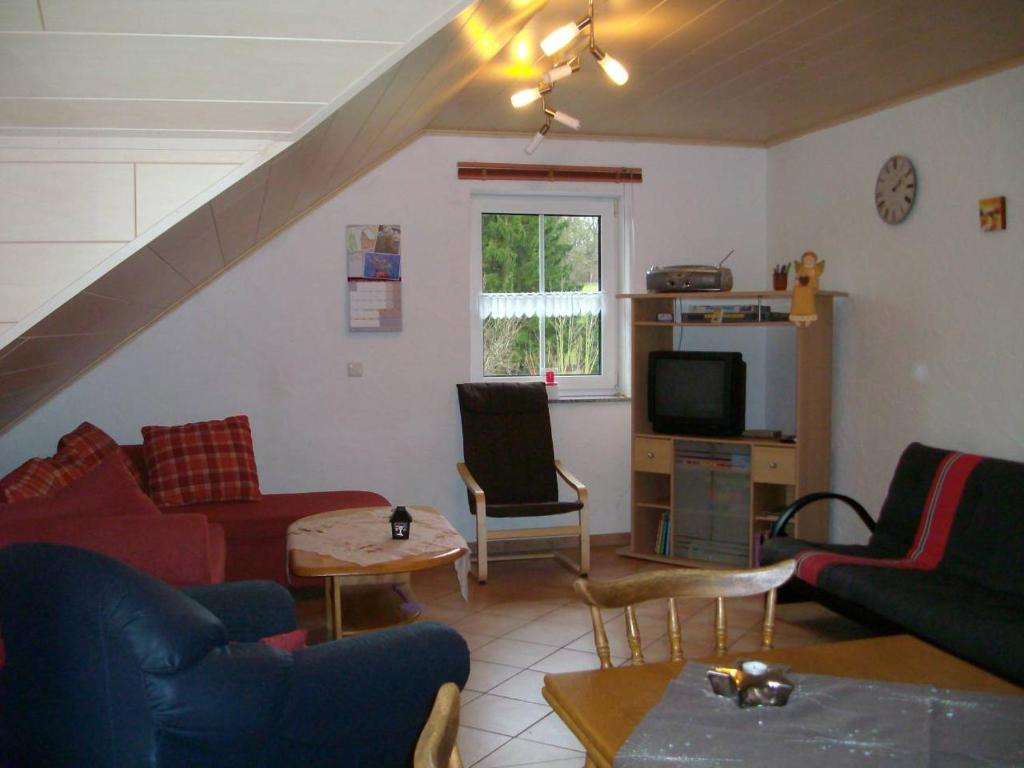een woonkamer met een bank en een tv bij Ferienwohnung Mastiaux in Mirbach