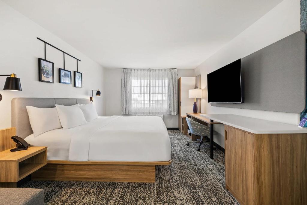 a hotel room with a bed and a desk at Sleep Inn & Suites Verona - Madison Southwest in Verona