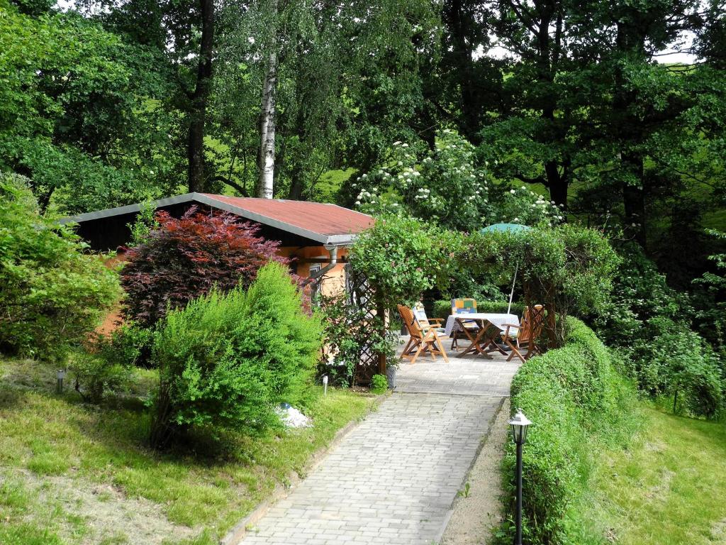 a walkway leading to a garden with a cabin at Ferienhaus am Urzeitpark Sebnitz in Hertigswalde