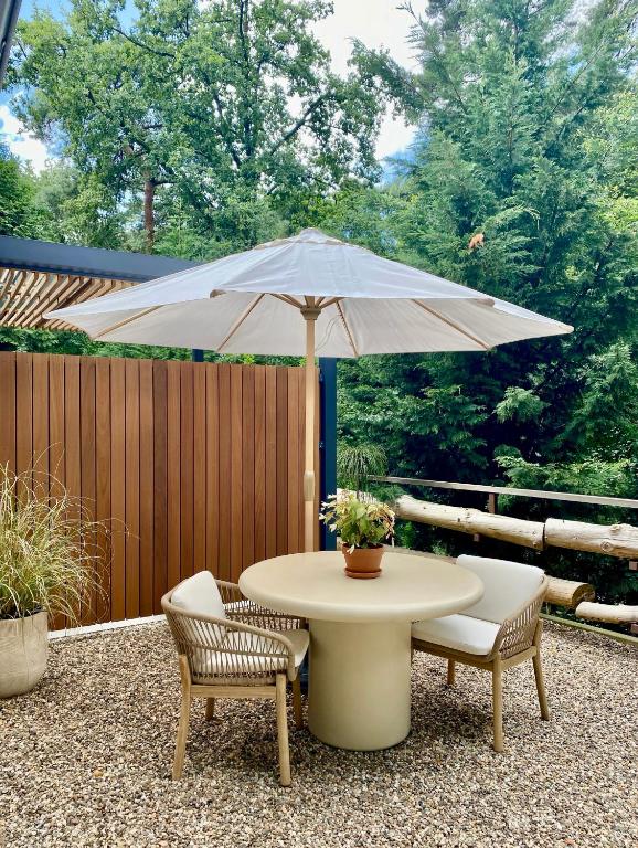 a table and chairs with an umbrella on a patio at ForRest Suites in Ermelo