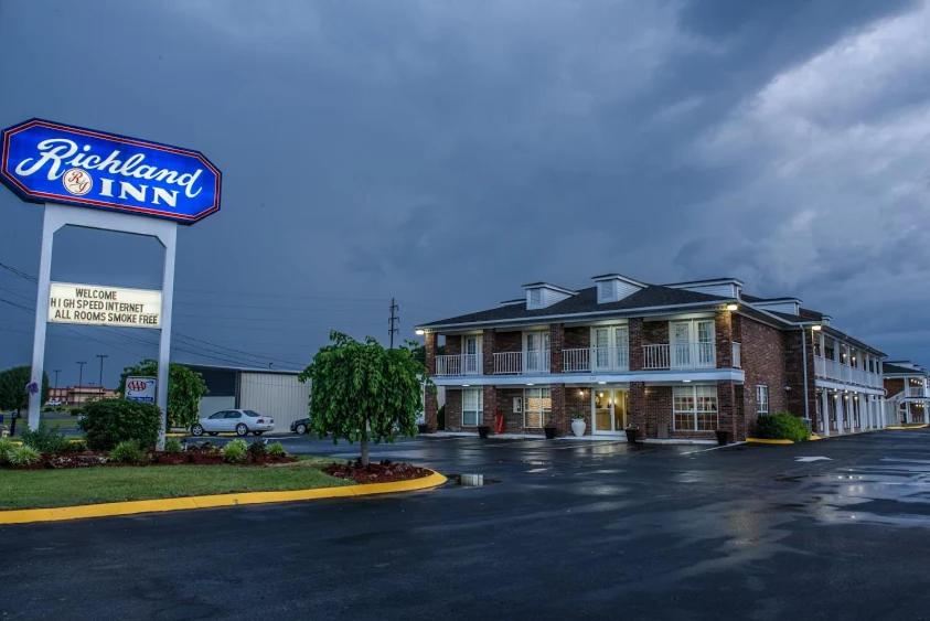 um hotel com uma placa num parque de estacionamento em Richland Inn em Lawrenceburg