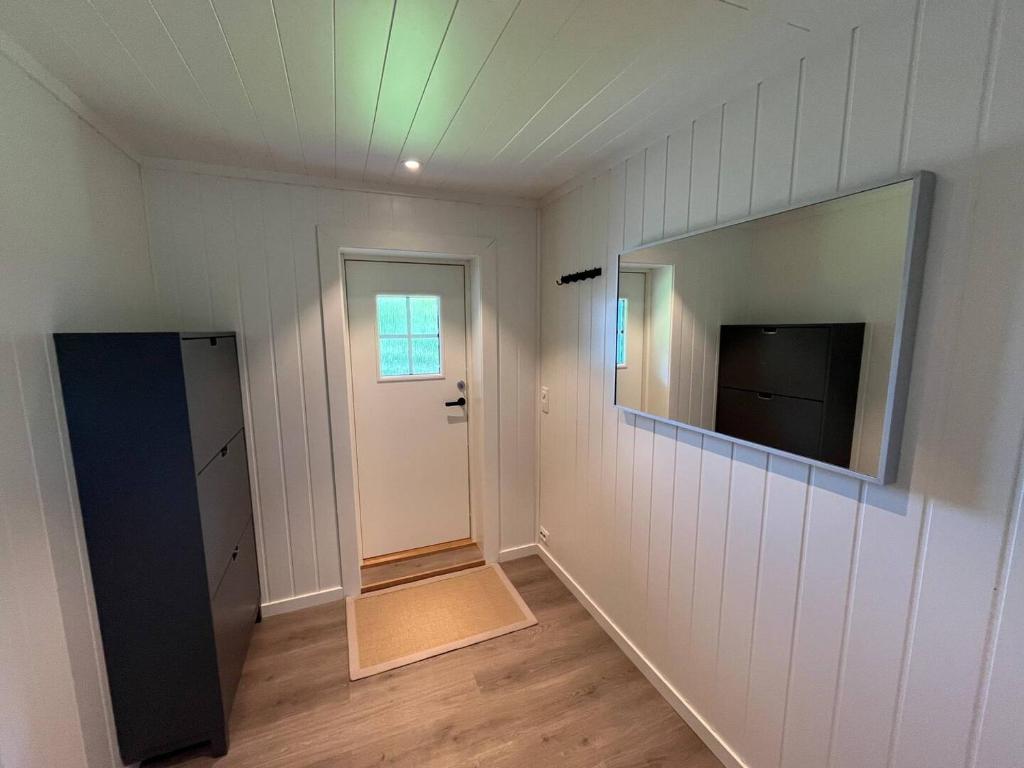 a room with a mirror and a door and a television at The simple appartment in Stryn in Stryn