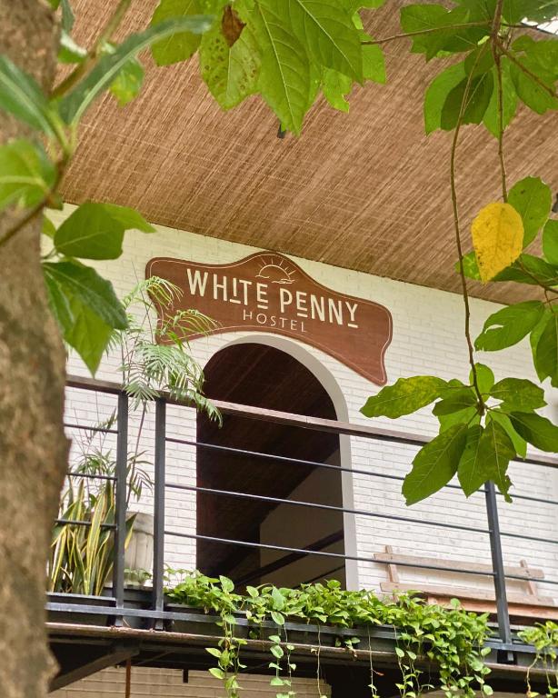 a sign for a white penniny house on a building at White Penny Hostel in Seminyak