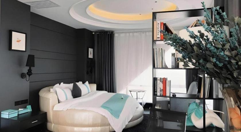 a bedroom with a bed and a book shelf at Xana Hotelle XiAn Gig Wild Goose Pagoda Branch in Xi'an