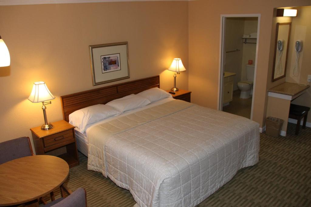 a hotel room with a large bed and a table at Villa Inn in San Rafael