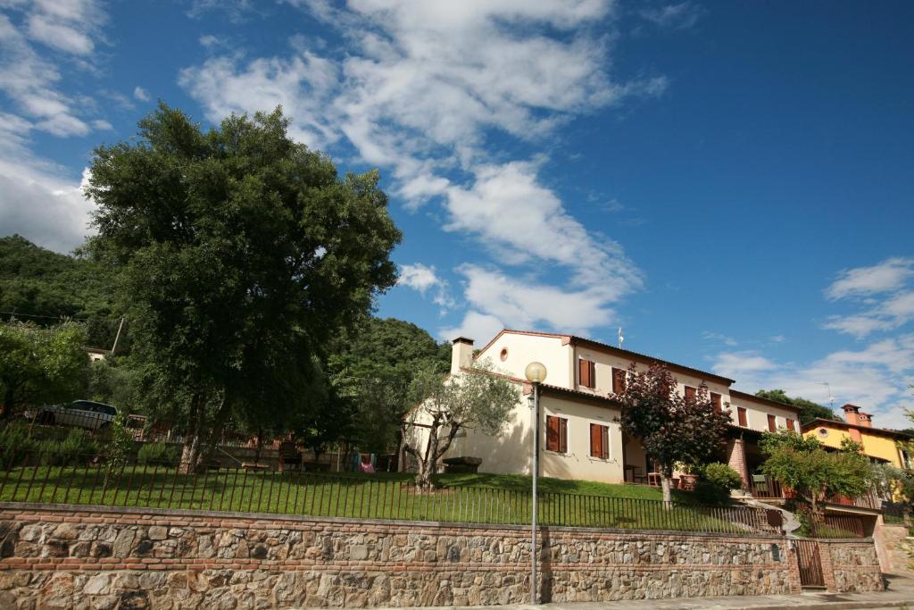 una casa con un árbol y una pared de piedra en B&B Contarine, en Cinto Euganeo