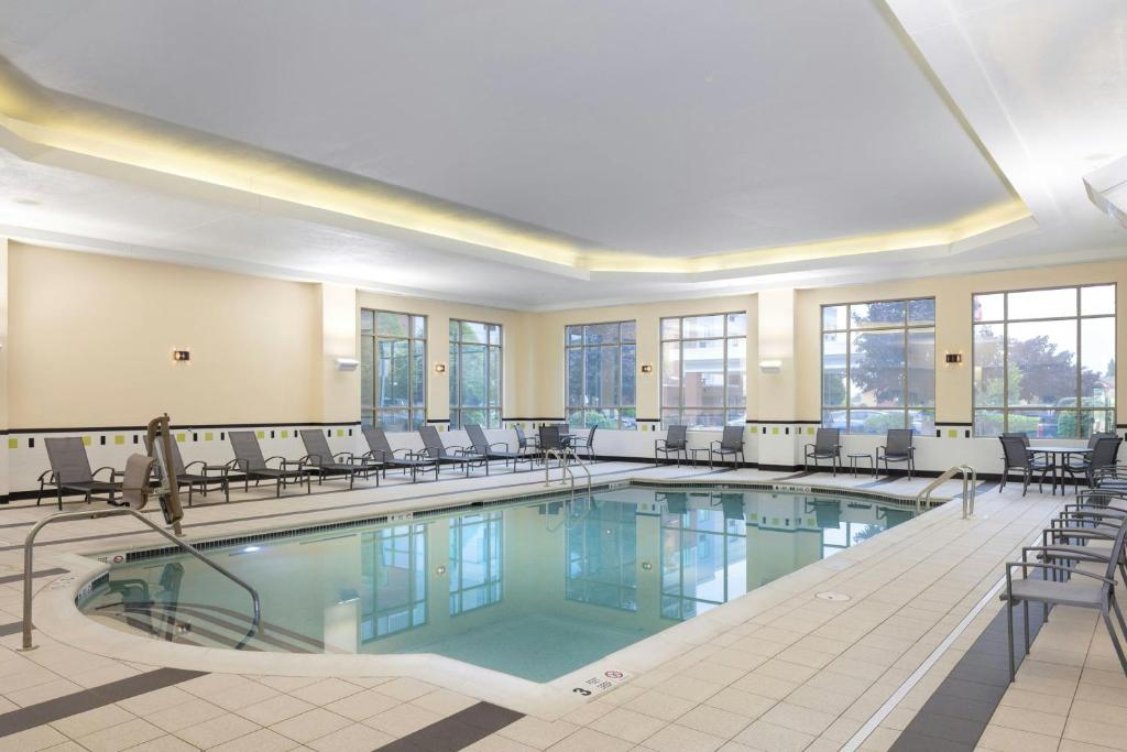 a large swimming pool with chairs in a building at Fairfield Inn & Suites – Buffalo Airport in Cheektowaga