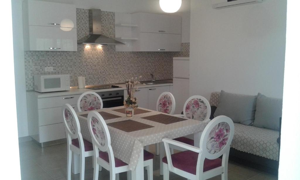 a kitchen with a dining room table and chairs at Apartments Milica in Rogoznica