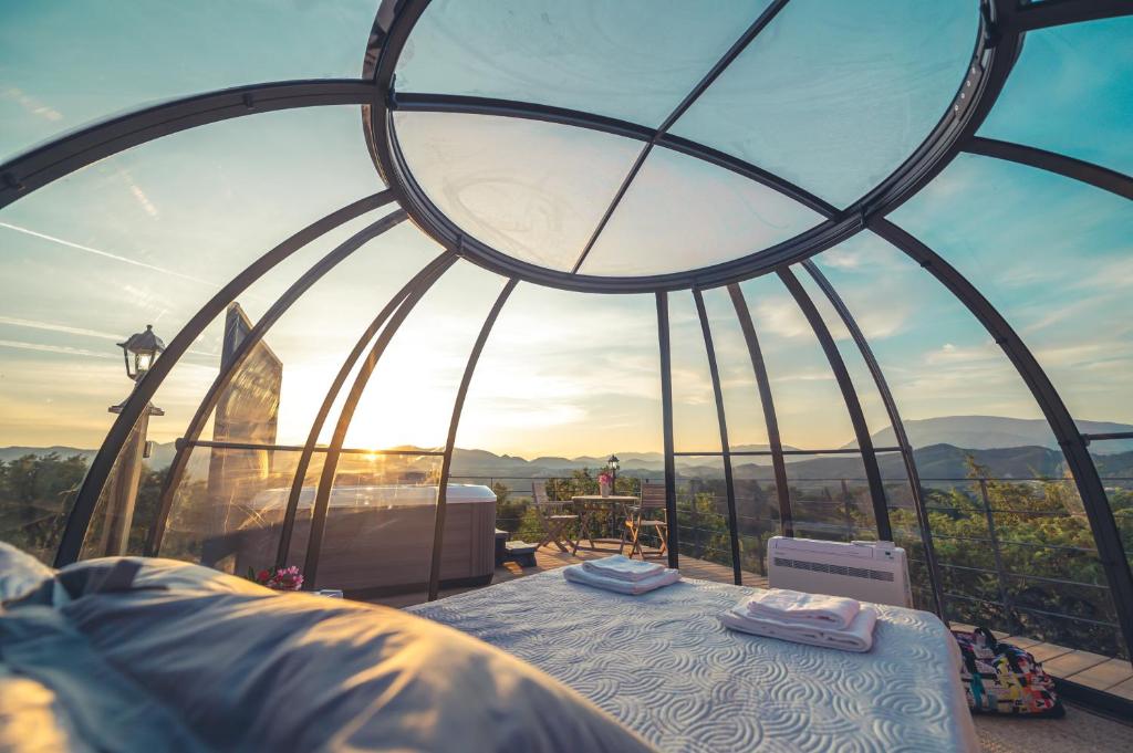une chambre avec un lit et une fenêtre avec vue dans l'établissement Les Dômes du Ventoux, à Saint-Romain-en-Viennois