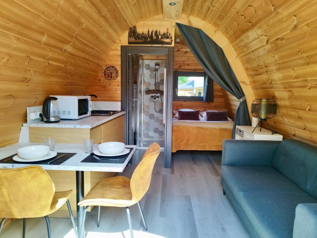 Cette chambre comprend une table, un canapé et un lit. dans l'établissement Cottage climatisé avec terrasse privative et kitchenette, à Avranches