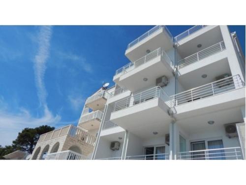 a white building with balconies on the side of it at Apartments King in Podstrana