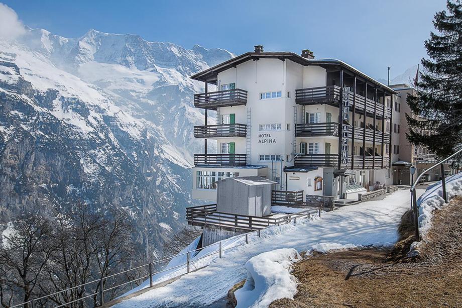 a building on top of a snow covered mountain at Hotel Alpina in Mürren