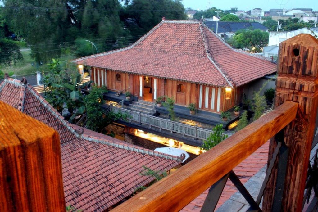 un bâtiment avec un toit rouge et une gare dans l'établissement Omah Sinten Heritage Hotel & Resto, à Solo